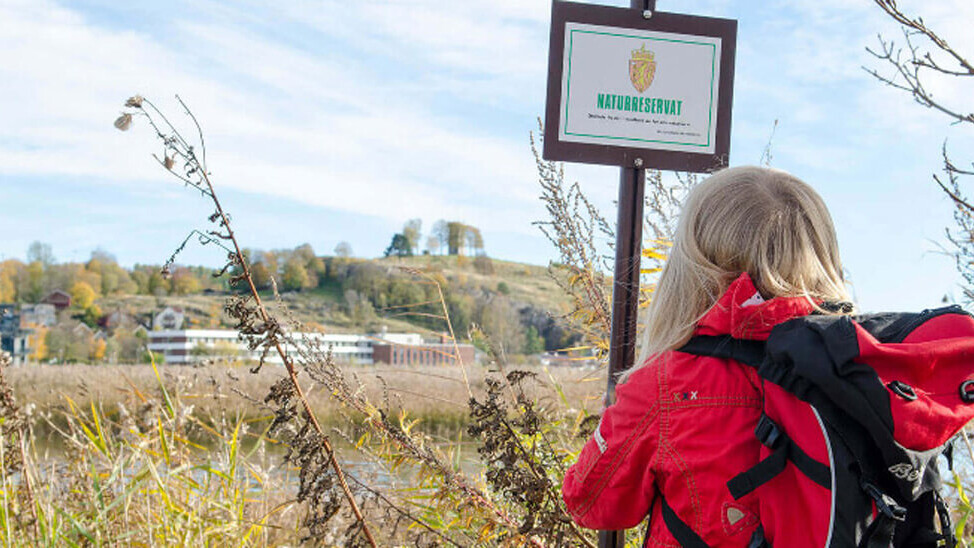 Jente foran verneskilt og våtmark